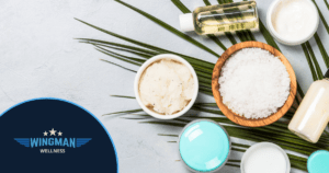 mental health - sugar scrub, cream, essential oils sitting on a palm leaf